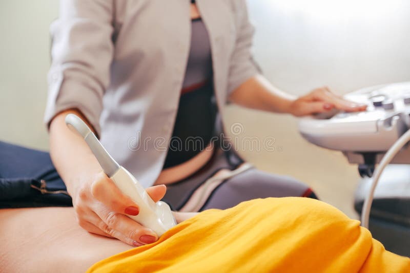 Doktor macht die geduldigen Frauen Abdominal- Ultraschall Ultraschallscanner in den Händen eines Doktors lizenzfreie stockfotos Doktor macht die geduldigen Frauen Abdominal- Ultraschall Ultraschallscanner in den Händen eines Doktors lizenzfreie stockfotos