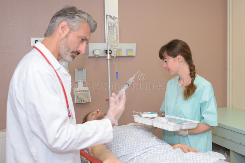Doktor och sjuksköterska som ger narkosläkare till patienten fotografering för bildbyråer Doktor och sjuksköterska som ger narkosläkare till patienten fotografering för bildbyråer