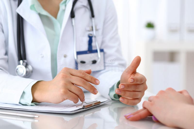 Doktor och tålmodigt samtal, medan sitta på skrivbordet i sjukhuskontoret, closeup av mänskliga händer Medicin och hälsa royaltyfri bild