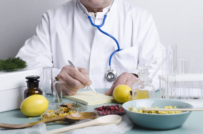 Doktor sitzt am Tisch Viele Inhaltsstoffe alternativer Arzneimittel Beeren, Kräuter, Zitronen und verschiedene Teile von Natura
