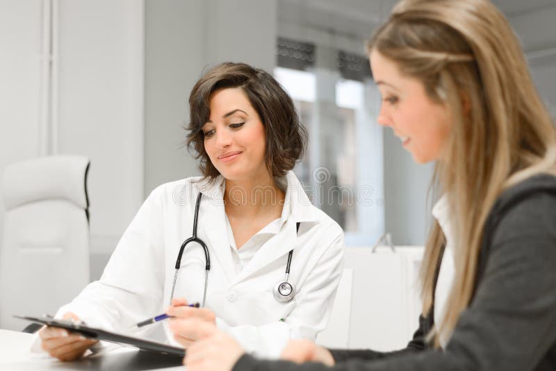 Doktor som förklarar diagnos till hennes kvinnliga patient arkivbilder Doktor som förklarar diagnos till hennes kvinnliga patient arkivbilder