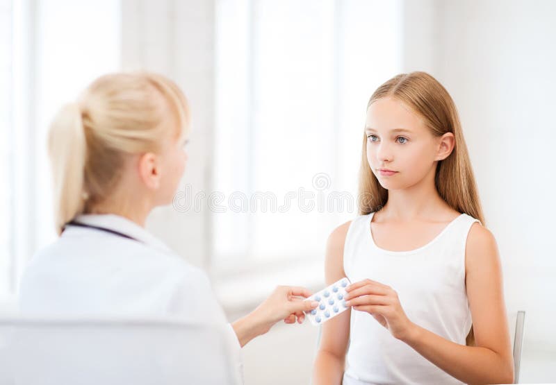 Doktor som ger minnestavlor till barnet i sjukhus arkivfoto Doktor som ger minnestavlor till barnet i sjukhus arkivfoto