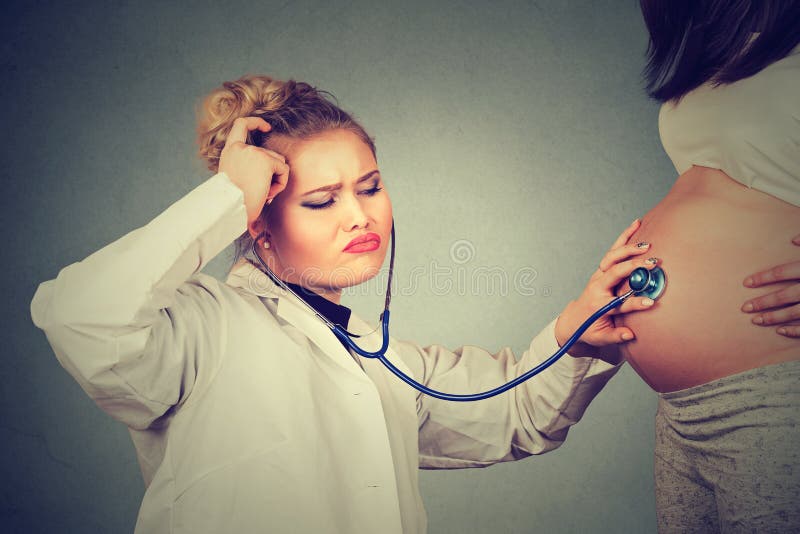 Doktor som lyssnar till den gravida patienten royaltyfri foto Doktor som lyssnar till den gravida patienten royaltyfri foto