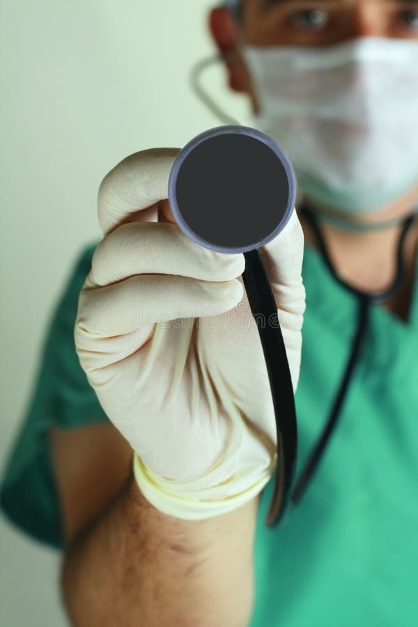 Doctor with stethoscope in an emergency or surgical room lighting environment. Selective focus on the stethoscope. Doctor with stethoscope in an emergency or surgical room lighting environment. Selective focus on the stethoscope.