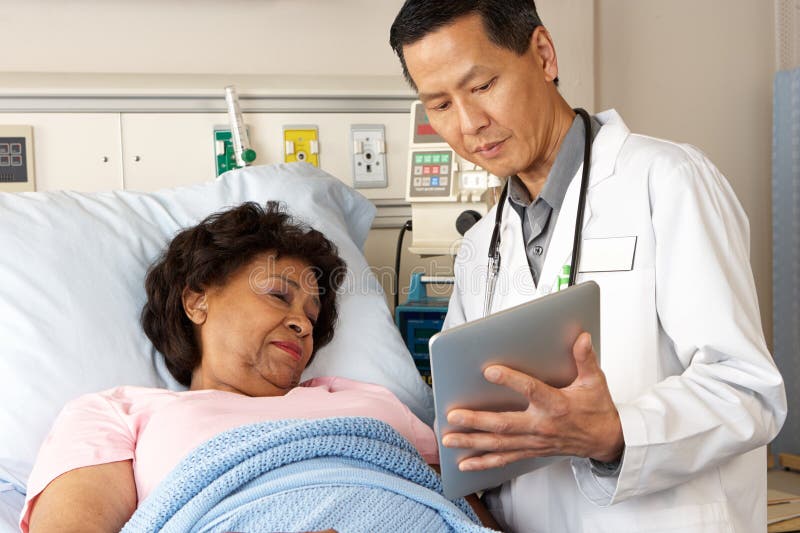 Doktor Using Digital Tablet Talking mit älterem Patienten lizenzfreies stockfoto Doktor Using Digital Tablet Talking mit älterem Patienten lizenzfreies stockfoto