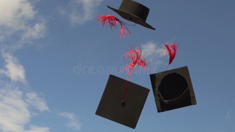 Doktorhuten, die in blauen Himmel, Hochschultradition fliegen, um akademische Kappen oben zu werfen