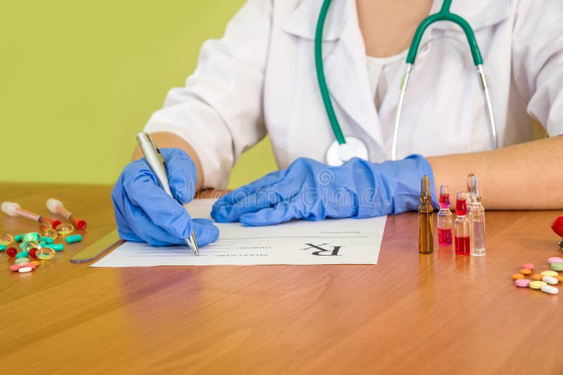 Doktorn räcker fyllningdokumentet med preventivpillerar och injektionssprutan royaltyfri bild Doktorn räcker fyllningdokumentet med preventivpillerar och injektionssprutan royaltyfri bild