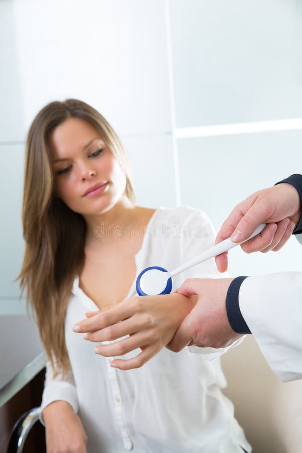 Doctor checking wrist with reflex round hammer to woman patient in hospital. Doctor checking wrist with reflex round hammer to woman patient in hospital