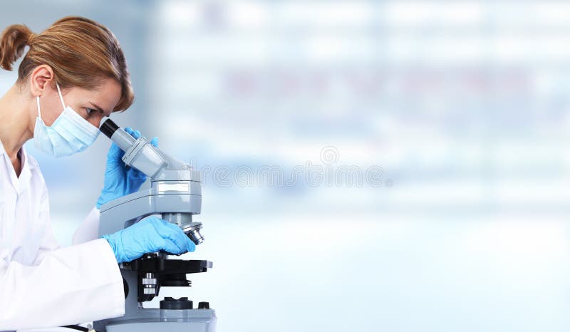 Doktorskvinna med mikroskopet arkivfoton