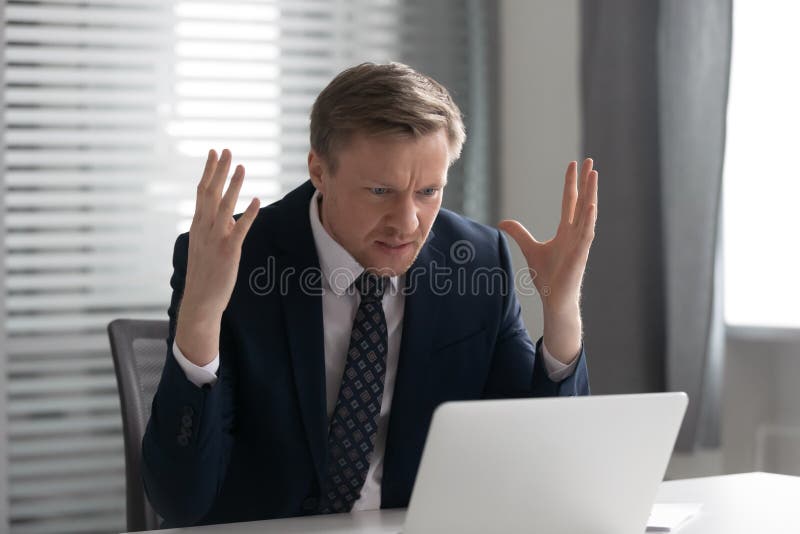Dokuczający szalenie biznesmen jest ubranym kostium udaremniającego z komputerowym problemem fotografia royalty free Dokuczający szalenie biznesmen jest ubranym kostium udaremniającego z komputerowym problemem fotografia royalty free