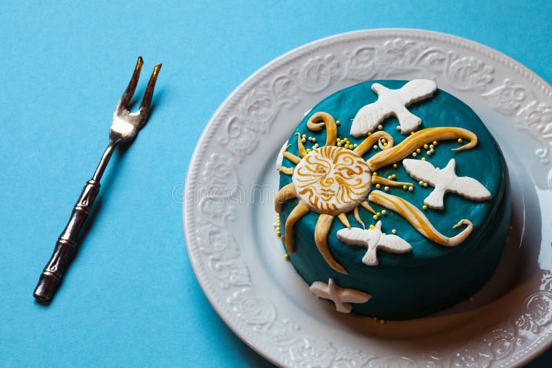 Dolce blu di Pasqua, sole giallo e colombe bianche nel piatto bianco con la forcella Priorità bassa per una scheda dell'invito o fotografie stock Dolce blu di Pasqua, sole giallo e colombe bianche nel piatto bianco con la forcella Priorità bassa per una scheda dell'invito o fotografie stock