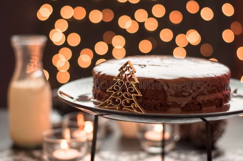 Dolce di cioccolato con le luci di natale confuse. fotografia stock libera da diritti Dolce di cioccolato con le luci di natale confuse. fotografia stock libera da diritti