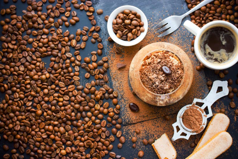 Dolce italiano tradizionale di tiramisù del dessert in vetro sulla tavola con fotografia stock Dolce italiano tradizionale di tiramisù del dessert in vetro sulla tavola con fotografia stock