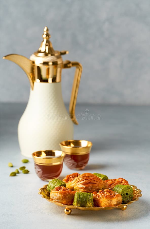 Baklava sweets with Arabic Coffee pot Dallah and cup of traditional  cardamon coffee Qahwa. Vertical. Baklava sweets with Arabic Coffee pot Dallah and cup of traditional  cardamon coffee Qahwa. Vertical