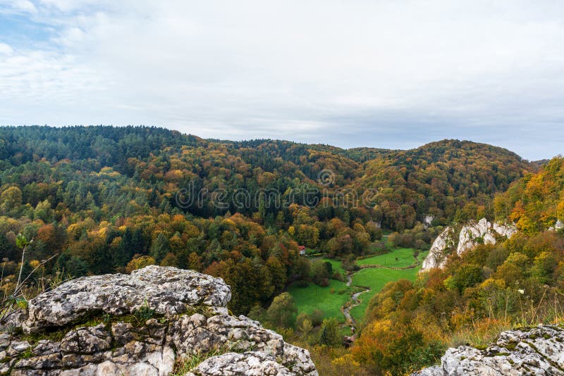 Dolina dolina pradnika z rzeką i wzgórzami pokrytymi kolorowym lasem i niewielkimi formacjami skał wapiennych powyżej w obrazy stock