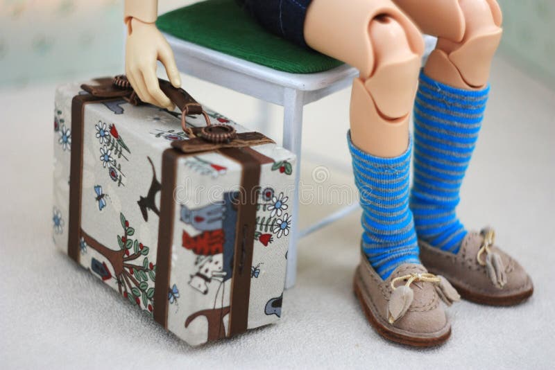 The doll is holding a miniature doll suitcase royalty free stock photography