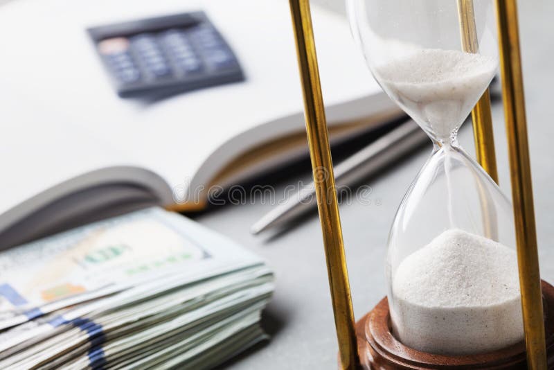 Dollar bills, hourglass and notebook for planning investments or cash expenses royalty free stock images Dollar bills, hourglass and notebook for planning investments or cash expenses royalty free stock images