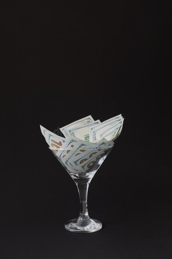 Dollar in Martini Glass. Glass is Full Hundred Dollar Bills Stock Photo
