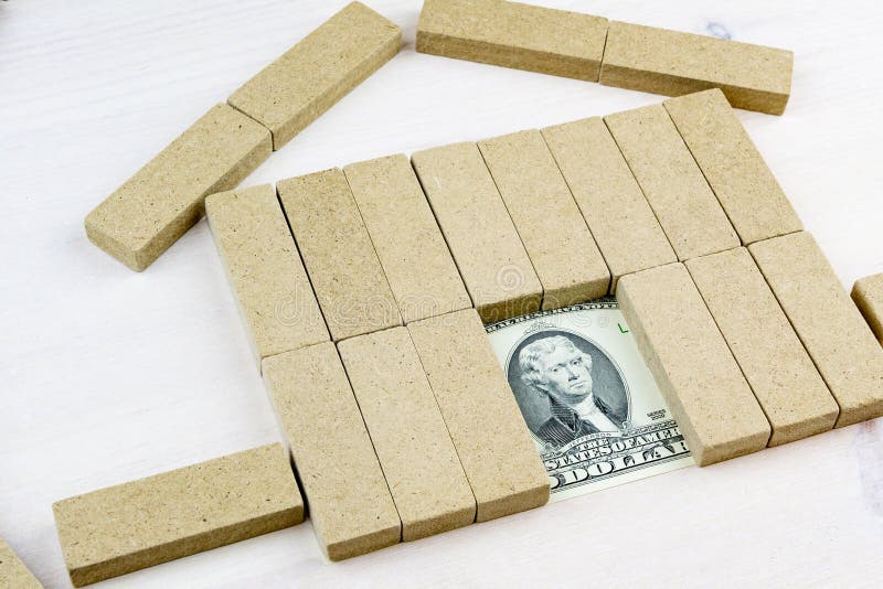 Dollars in the Doors of a Toy House Assembled on a Wooden Stock Image