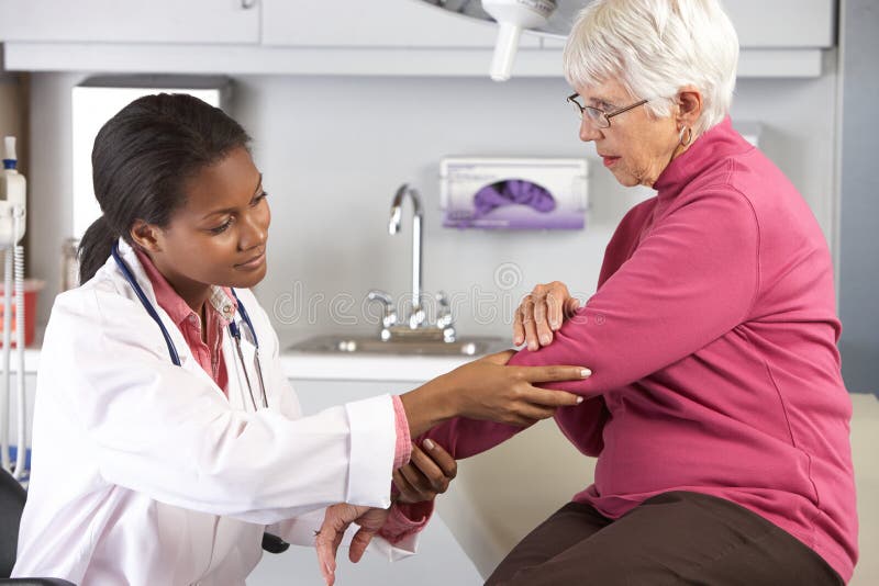 Dolore del gomito del dottore Examining Female Patient With fotografia stock libera da diritti