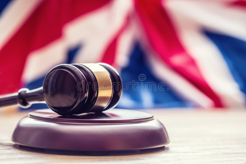 Judges wooden gavel with UK flag in the background. Symbol for jurisdiction. Judges wooden gavel with UK flag in the background. Symbol for jurisdiction.