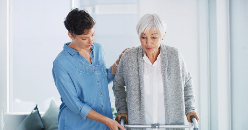Domiciliare e anziana donna con camminatore per cure mediche o aiuto in pensione. Fisioterapista immagini stock libere da diritti