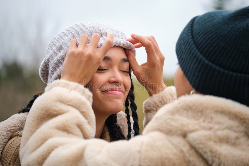 Dominican Lesbian Woman Putting A Woolen Hat On Her Girlfriend Head