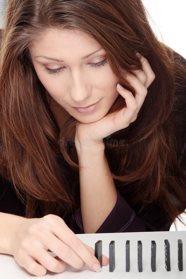 Young woman is concentrated in building a domino