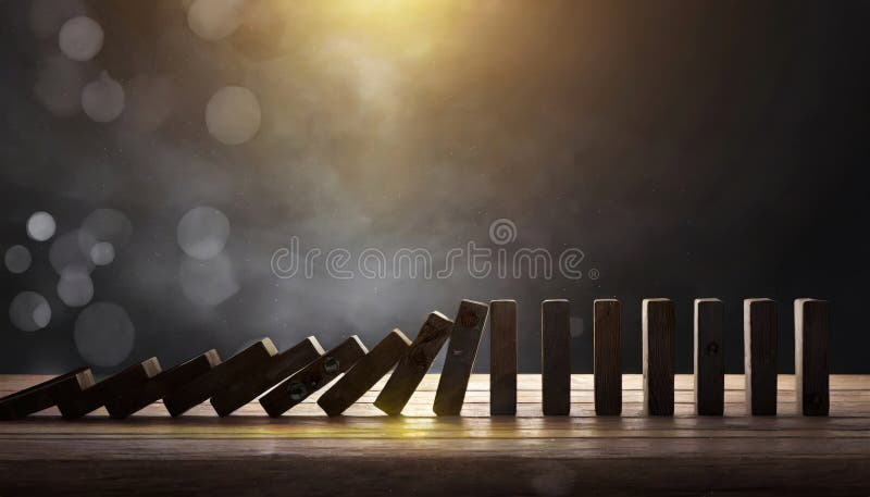 Dominoes topping in a line in dark environment copy space royalty free stock image