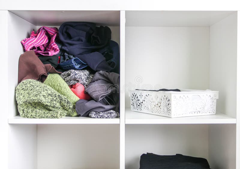 Home wardrobe with different clothes. Small space organization. The contrast of order and disorder. Home wardrobe with different clothes. Small space organization. The contrast of order and disorder