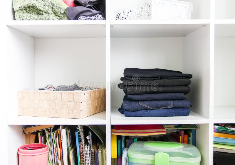 Home wardrobe with different clothes. Small space organization. The contrast of order and disorder. Home wardrobe with different clothes. Small space organization. The contrast of order and disorder