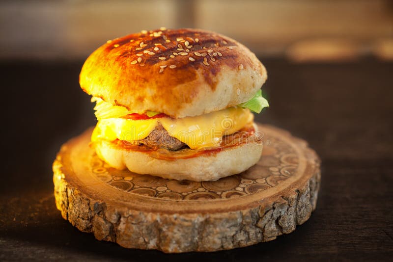 Domowej roboty hamburger na drewnianej desce Zmierzchu światło obraz royalty free Domowej roboty hamburger na drewnianej desce Zmierzchu światło obraz royalty free
