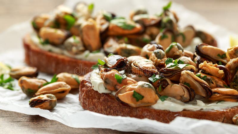 Domowej roboty Mussels na piec na grillu bruschetta, grzance z mi?kkim serem i ziele, obraz stock Domowej roboty Mussels na piec na grillu bruschetta, grzance z mi?kkim serem i ziele, obraz stock
