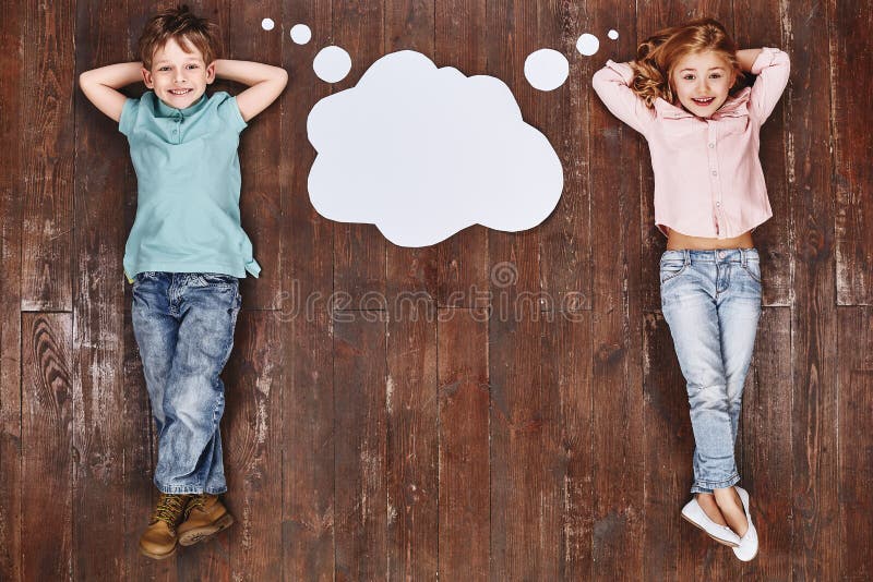 Don`t call it a dream, call it a plan. Children lying near empty thought cloud, looking at camera and smiling stock images Don`t call it a dream, call it a plan. Children lying near empty thought cloud, looking at camera and smiling stock images