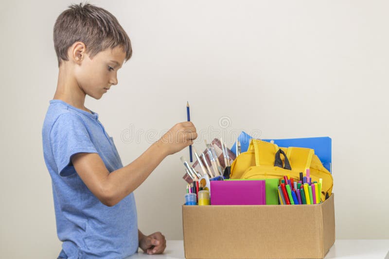 Donation concept. Kid preparing donate box with books, pencils and school supplies for donation royalty free stock photos Donation concept. Kid preparing donate box with books, pencils and school supplies for donation royalty free stock photos