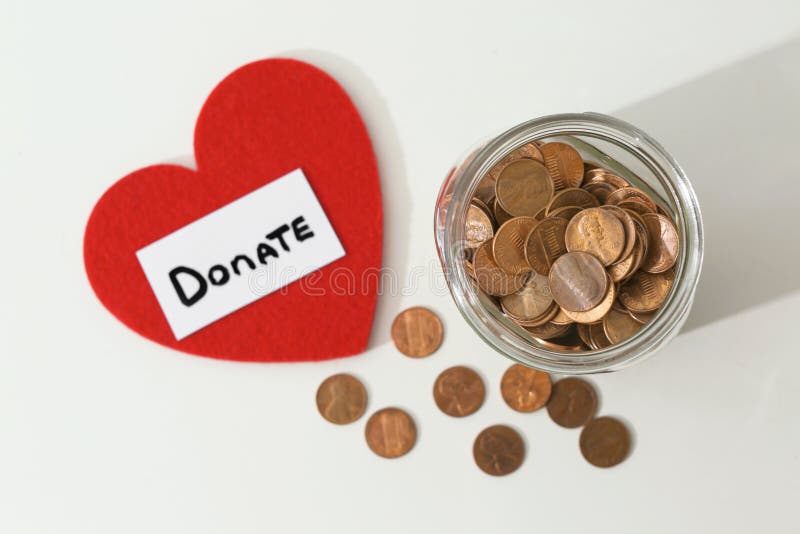 Donation jar, coins and red heart on white background