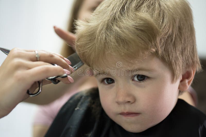 Donde está juego el corte de pelo de los childs Pequeño niño en salón de la peluquería Corte de pelo dado del pequeño niño Niño p fotografía de archivo Donde está juego el corte de pelo de los childs Pequeño niño en salón de la peluquería Corte de pelo dado del pequeño niño Niño p fotografía de archivo