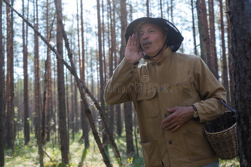 Donde está usted concepto Pierden al hombre europeo maduro vestido en la ropa vieja que sostiene la cesta en bosque imagen de archivo libre de regalías Donde está usted concepto Pierden al hombre europeo maduro vestido en la ropa vieja que sostiene la cesta en bosque imagen de archivo libre de regalías