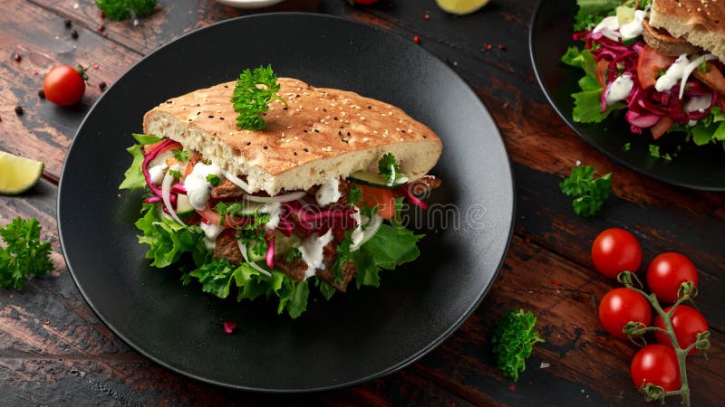 Doner kebab, fried lamb meat with vegetables and garlic sauce in turkish bread