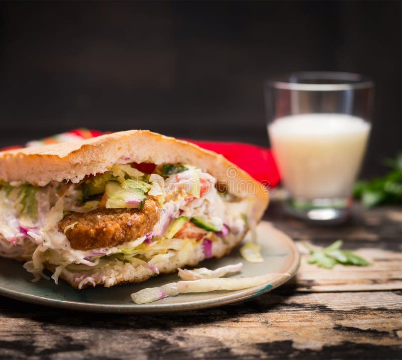 Doner kebab with meat, sauce and vegetables with a glass airan on a plate On wooden rustic background, close up stock photos Doner kebab with meat, sauce and vegetables with a glass airan on a plate On wooden rustic background, close up stock photos