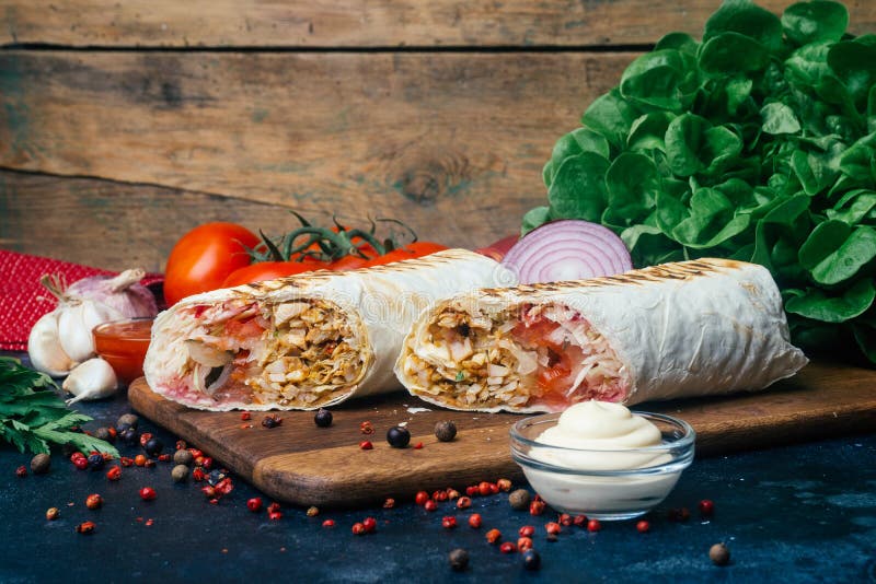 Doner kebab shawarma or doner wrap. Grilled chicken on lavash pita bread with fresh vegetables - tomatoes, green salad
