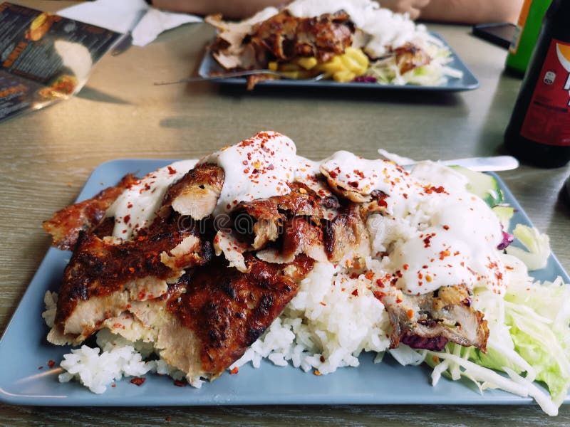 Doner Kebap on a plate with rice and a variation of salads. Spicy savory Doner Kebap or Kebab on a place with white Turkish rice and a variation of salads royalty free stock image Doner Kebap on a plate with rice and a variation of salads. Spicy savory Doner Kebap or Kebab on a place with white Turkish rice and a variation of salads royalty free stock image