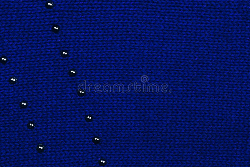 Donkerblauwe gebreide stof met zichtbaar gebreid patroon en het zwarte ornament van metaalpunten Hoogste mening De ruimte van het royalty-vrije stock afbeeldingen Donkerblauwe gebreide stof met zichtbaar gebreid patroon en het zwarte ornament van metaalpunten Hoogste mening De ruimte van het royalty-vrije stock afbeeldingen