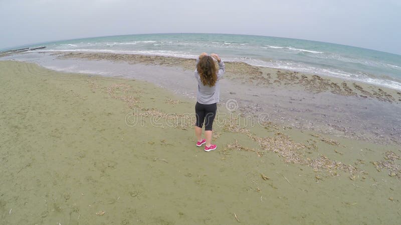 Donkerbruin meisje die zich op het strand bevinden en van koele mening over overzees genieten, ontspanning