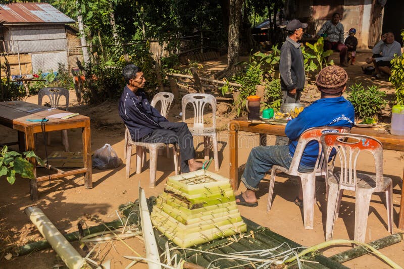 DONKHOUN, LAOS - NOVEMBER 27, 2019: Villagers preparing floating vessel to appease spirits in Donkhoun &#x28;Done Khoun&#x29; village near Nong Khiaw, Laos. DONKHOUN, LAOS - NOVEMBER 27, 2019: Villagers preparing floating vessel to appease spirits in Donkhoun &#x28;Done Khoun&#x29; village near Nong Khiaw, Laos