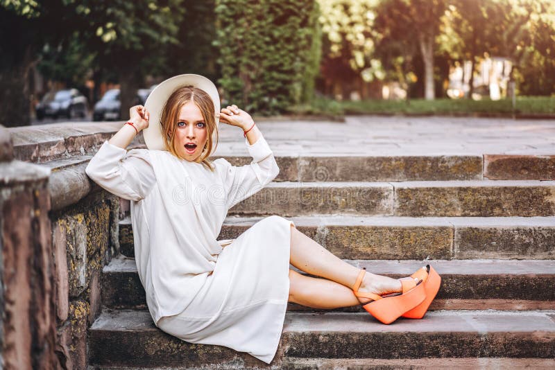 Donna abbastanza emozionante in vestito avvantaggioso bianco all'aperto fotografia stock Donna abbastanza emozionante in vestito avvantaggioso bianco all'aperto fotografia stock