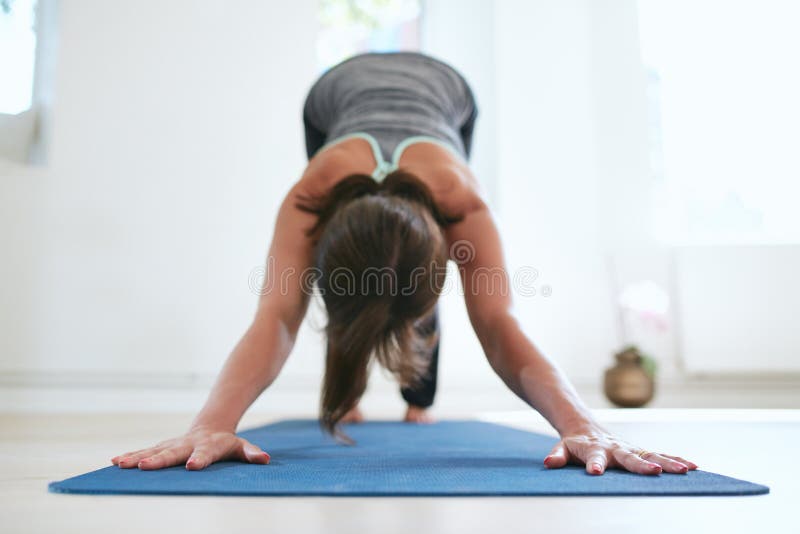 Donna adatta in una posa meditativa di yoga alla palestra fotografie stock libere da diritti Donna adatta in una posa meditativa di yoga alla palestra fotografie stock libere da diritti