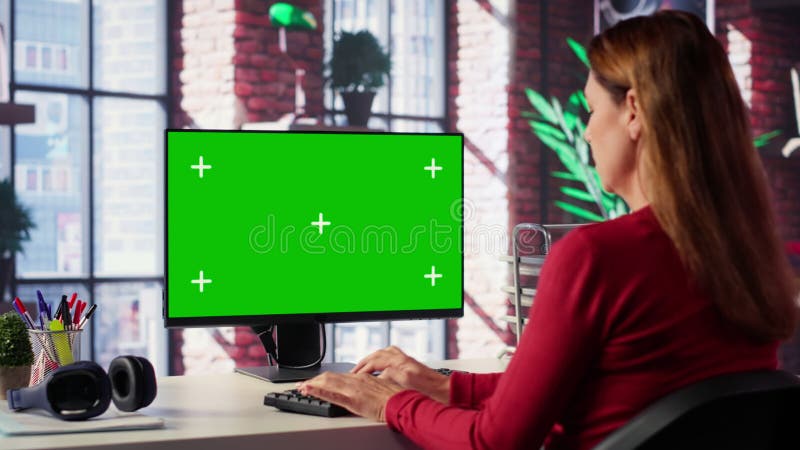 Donna adulta che scrive sulla pc con la chiave chroma nella sua scrivania stock footage
