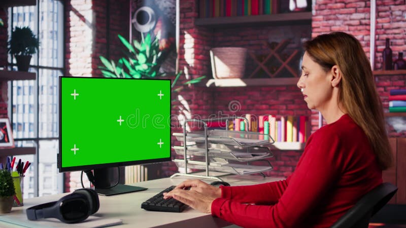 Donna adulta che scrive sulla pc con la chiave chroma nella sua scrivania video d archivio