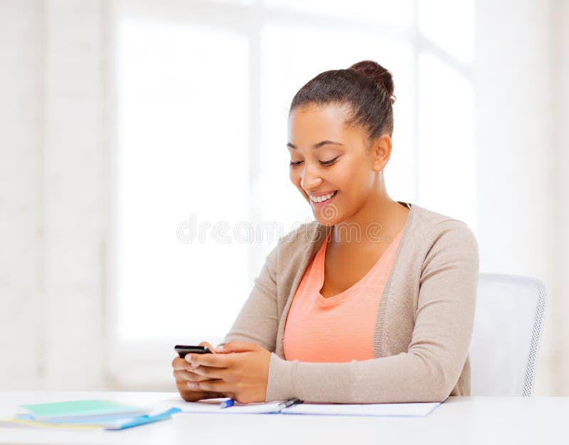 Donna africana con smartphone in ufficio fotografia stock